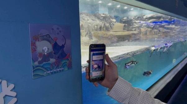 관객이 극지방존에서 AR 스탬프 투어 미션을 수행하고 있다.