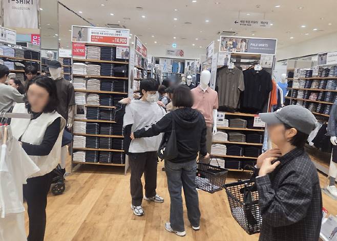 매장 내부에서 고객들이 티셔츠를 고르며 쇼핑을 즐기고 있다. 리뉴얼을 통해 동선과 진열이 개선됐다. (사진=한전진 기자)