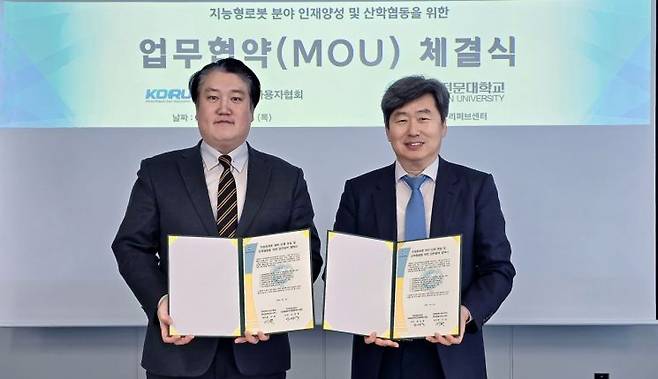안상욱 영진전문대 지능형로봇 혁신융합대학사업단장(오른쪽)과 이 천 한국로봇리퍼브센터 센터장이 산학협력 협약 체결에 나선 모습.