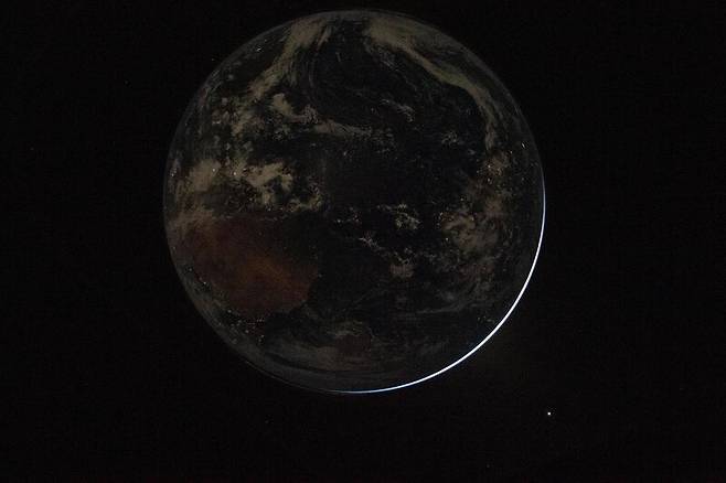 어둠에 휩싸인 지구. 초승달 모양의 햇빛이 새어나오고 있다. 미국항공우주국 제공