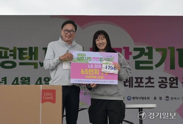 박종근 평택시체육회장이 경품 TV를 받은 참가자와 기념촬영을 하고 있다. 윤원규기자