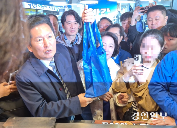 더불어민주당 정청래 당대표가 6일 수원 못골시장을 찾아 파란색 장바구니를 들어보이고 있다. 2026.4.6 /김태강 기자 think@kyeongin.com