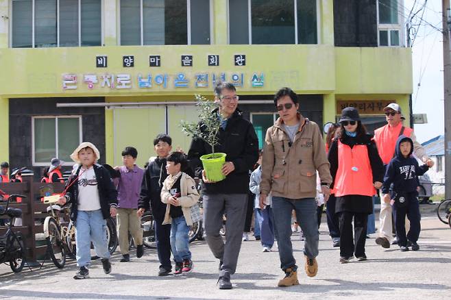 드론배송된 올리브묘목을 농장으로 운반하는 이영근 한국관광공사 제주지사장(왼쪽)과 고성민 비양리장(오른쪽)