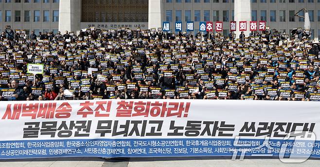 19일 서울 여의도 국회 본청 앞 계단에서 열린 대형마트 온라인 새벽배송 추진 반대 집회에서 참가자들이 대형마트 새벽배송 추진 철회를 촉구하고 있다. 2026.3.19 ⓒ 뉴스1 이승배 기자