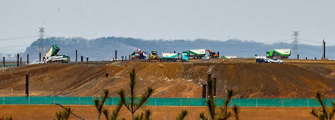 수도권 생활폐기물 직매립 금지 시행 100일이 다가오는 가운데 1일 인천 서구 수도권매립지 제3-1매립장에서 덤프트럭들이 오가며 수도권 쓰레기를 쏟아내고 있다. 덤프트럭 사이에서 용수 차량이 악취 저감을 위해 물을 뿌리고 있다. 인천=유희태 기자