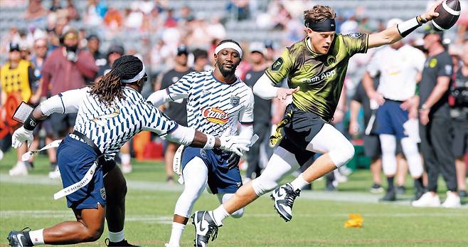 지난달 21일 미국 LA BMO 스타디움에서 열린 플래그 풋볼 이벤트 경기에서 NFL(미 프로풋볼) 신시내티 벵갈스 쿼터백 조 버로(오른쪽)가 터치다운을 시도하고 있다. 버로를 수비하는 선수는 라스베이거스 레이더스의 러닝백 애쉬턴 젠티(왼쪽)와 지난해 은퇴한 프로복서 테런스 크로퍼드(가운데)다. /게티이미지코리아