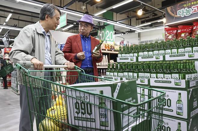 조웅래 선양소주 회장(오른쪽)이 6일 오전 서울 송파구 농수산물도매시장 가락몰 다농마트에서 한 소비자에게 '착한소주 990'을 소개하고 있다. '착한소주 990'은 조웅래 회장이 직접 광고 모델로 참여해 마케팅 비용을 줄이고, 이를 가격 인하에 반영해 출시된 동네슈퍼 전용 상품이다. 소비자 가격은 병당 990원(도수 16도·360mL 제품)이며, 한 박스(20병) 기준 1만 9800원이다. 임형택 기자