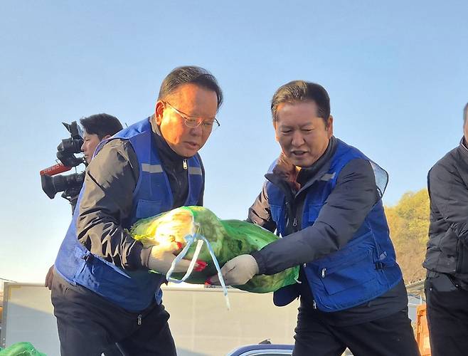 (왼쪽부터)대구시장 선거에 공식 출마 선언한 김부겸 전 국무총리와 더불어민주당 정청래 대표가 8일 대구 북구 대구농수산물도매시장에서 민생현장 체험으로 배추를 나르고 있다.