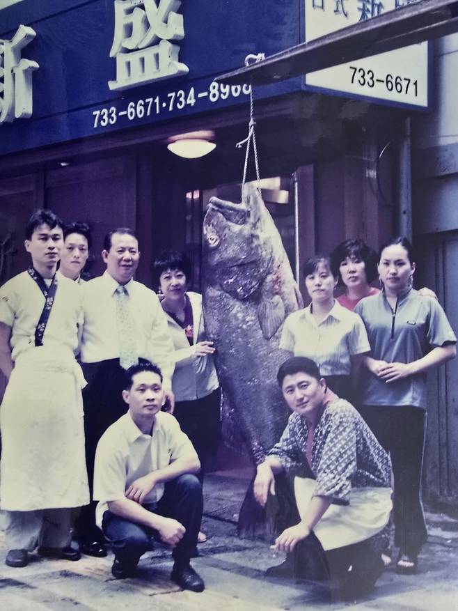 신성일식 문채환 사장(왼쪽에서 세 번째)과 김상희 전무(네 번째), 식당 직원들이 2006년 7월 남해에서 올라온 거대한 돗돔과 같이 찍은 사진. 신성일식 제공