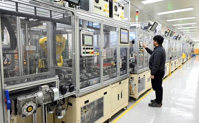 지엠비코리아 창원2공장 직원이 전동식 워터펌프 조립 라인 상태를 점검하고 있다. 17개 공정으로 구성된 라인에는 산업용 로봇암이 설치돼 부품 조립부터 검사까지 자동화 공정이 이어진다.