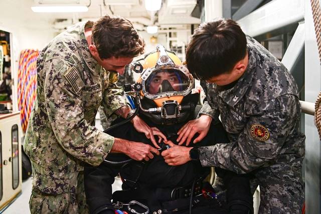 8일 경남 진해만 일대에서 진행된 연합 구조전 훈련에서 수상함구조함 통영함(ATS-Ⅱ, 3500t급)에 편승한 한미 해군 잠수사들이 호주 해군 잠수사의 잠수장비 착용을 돕고 있다.해군 제공