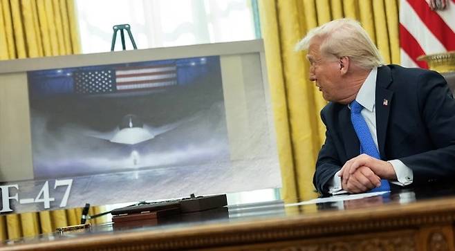 도널드 트럼프 미국 대통령이 21일(현지시간) 워싱턴 백악관 집무실에서 미국 차세대 전투기 F-47 관련 자료를 공개하고 있다. 2025.3.21 워싱턴 로이터 연합뉴스
