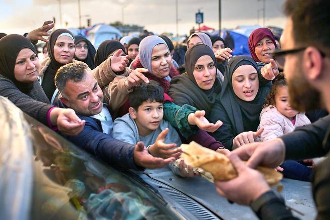 어른도…아이도…"제발 먹을 것 좀 주세요"9일(현지시간) 레바논 베이루트에 있는 피란민 텐트촌에서 이스라엘의 공습을 피해 온 시민들이 식량을 받기 위해 손을 내밀고 있다. 미국과 이란의 휴전 첫날인 지난 8일 친이란 무장정파 헤즈볼라를 겨냥한 이스라엘의 맹폭에 숨진 사람이 300명이 넘고, 1150명이 다쳤다고 레바논 보건부는 이날 밝혔다. AP뉴시스