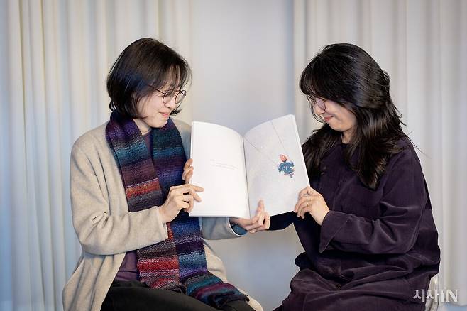 두 작가가 책 속의 그네 타는 그림을 함께 응시하고 있다. ⓒ시사IN 박미소