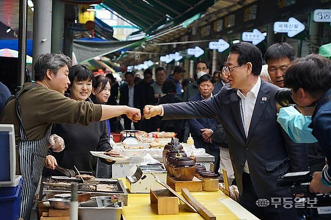 지난 10일 오전 순천웃장을 방문한 김영록 더불어민주당 전남광주통합특별시장 경선 후보가 상인과 주먹을 맞대며 인사를 하고 있다.