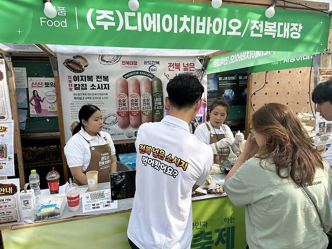 11일 전북 전주시 전북대학교에 마련된 ‘4월 동행축제’ 개막 판매전의 디에이치바이오 부스에서 시민들이 전복 관련 상품 설명을 듣고 있다.(서이원 기자 @iwonseo96)