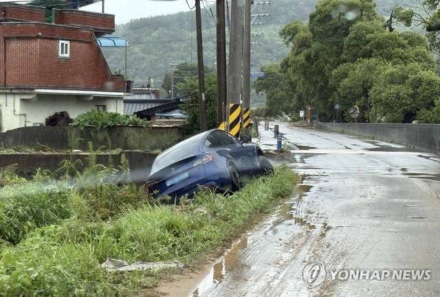 지난해 7월 19일 경남 합천에 내린 폭우로 한 마을 배수로에 승용차 한 대가 빠져 있다. 연합뉴스