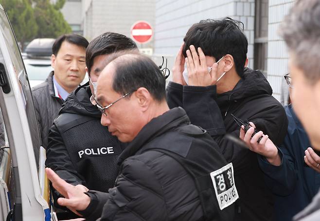 보복 대행 조직 총책(마스크 쓰고 얼굴 가린 남성)이 지난 3일 검찰로 구속 송치되고 있다. 직원을 배달의민족 외주사에 상담사로 위장 취업시킨 뒤 고객 정보를 빼돌려 범행에 활용한 혐의 등을 받고 있다. /연합뉴스