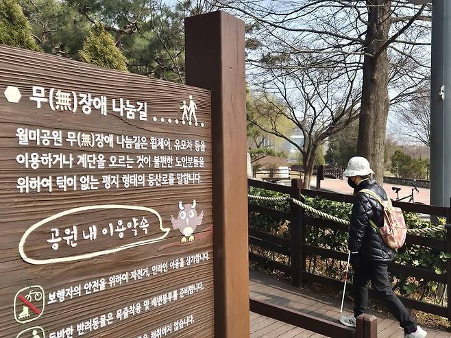 ▲ 지난달 27일 오후 인천 중구 월미공원의 무장애나눔길을 오르는 보행환경지킴이. 이 안내문에는 점자가 따로 표기돼 있지 않다. /안지섭 기자 ajs@incheonilbo.com