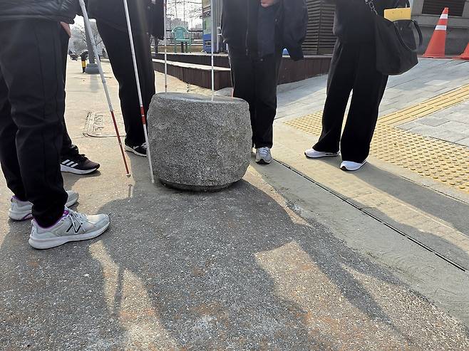 ▲ 지난달 27일 오후 인천 중구 월미공원 서문 쪽 화장실 앞에 설치된 돌 앞에서 시각장애인들이 보행 환경에 대한 우려를 나타내고 있다. /곽안나 기자 lucete237@incheonilbo.com