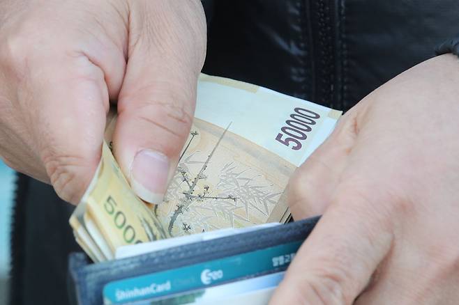 한 시민이 지갑에서 현금을 꺼내고 있다.(사진=뉴시스)