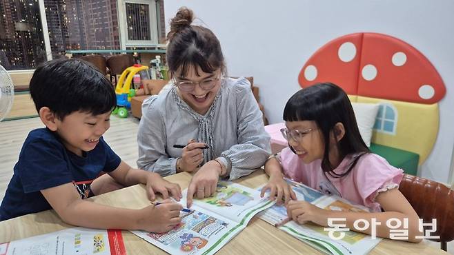 지난달 26일(현지 시간) 베트남 호찌민 안푸 지역의 한 가정에서 초등학생 민민 양(8·오른쪽)과 뚜어민 군(6·왼쪽)이 한국 학습지로 수학 교사(가운데)와 공부하고 있다. 호찌민=주현우 기자 woojoo@donga.com
