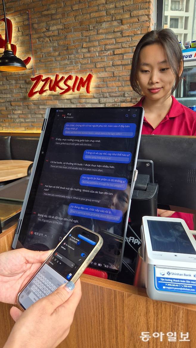 지난달 27일(현지 시간) 베트남 호찌민 타오디엔 지역의 한국식 주꾸미 식당 ‘쭉심’에서 한국인 직원과 베트남인 손님이 AI동시 통역 태블릿으로 소통하고 있다. 호찌민=주현우 기자 woojoo@donga.com