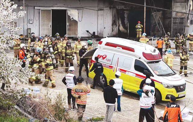 소방관들이 12일 전남 완도군 군외면 수산물 가공업체 냉동창고에서 난 화재를 진압하다가 숨진 채 발견된 동료가 이송되는 모습을 지켜보고 있다. 연합뉴스