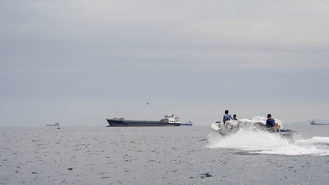 12일(현지 시간) 호르무즈 해협에서 한 대의 보트가 유조선을 향해 다가가고 있다. 로이터연합뉴스