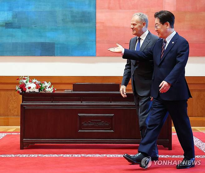 이재명 대통령과 투스크 폴란드 총리 (서울=연합뉴스) 김도훈 기자 = 이재명 대통령이 13일 청와대에서 공식 방한한 도날트 투스크 폴란드 총리와 기념 촬영을 위해 이동하고 있다. 2026.4.13 superdoo82@yna.co.kr