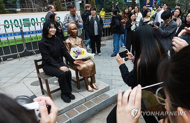 시민 곁으로 돌아온 소녀상 (서울=연합뉴스) 한종찬 기자 = 1일 서울 종로구 옛 주한 일본대사관 앞에서 열린 제1746차 일본군 성노예제 문제해결을 위한 정기 수요시위에서 참석자들이 평화의 소녀상과 함께 기념촬영을 하고 있다.
소녀상은 위안부 반대 단체의 집회로 훼손을 우려한 정의연의 요청으로 2020년 6월부터 바리케이드에 둘러싸였다. 그러나 최근 위안부법폐지국민행동 김병헌 대표가 사자명예훼손 등 혐의로 구속되며 철거 논의가 본격화했다. 종로구청과 종로경찰서는 반대 단체의 움직임을 고려해 집회 시간에만 일시 개방하기로 했다. 2026.4.1 saba@yna.co.kr