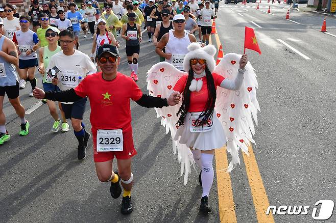 경북 경주시 보문단지에서 열린 제31회 경주벚꽃마라톤대회에 참가한 베트남 관광객이 이색 복장으로 달리고 있다. 2024.4.6 ⓒ 뉴스1