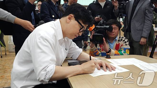 한동훈 전 국민의힘 대표가 14일 부산 북구 만덕2동 주민센터에서 전입신고서에 서명하고 있다. (한 전 대표측 제공. 재판매 및 DB 금지) 2026.4.14 ⓒ 뉴스1