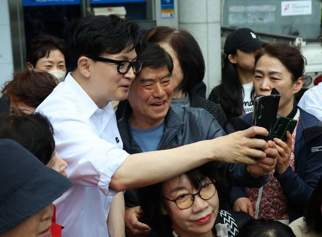 한동훈 전 국민의힘 당대표가 14일 오후 부산 북구 만덕2동 행정복지센터를 찾아 전입신고를 마친 뒤 주민들과 사진을 찍고 있다. 연합뉴스