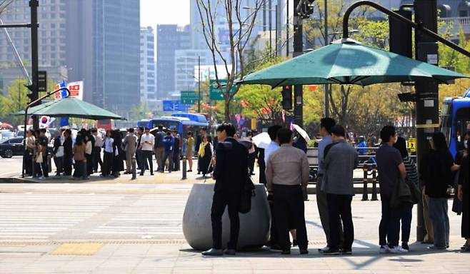 ▲15일 서울 광화문역 네거리에서 시민들이 그늘막 아래 모여 있다. (사진=연합뉴스)