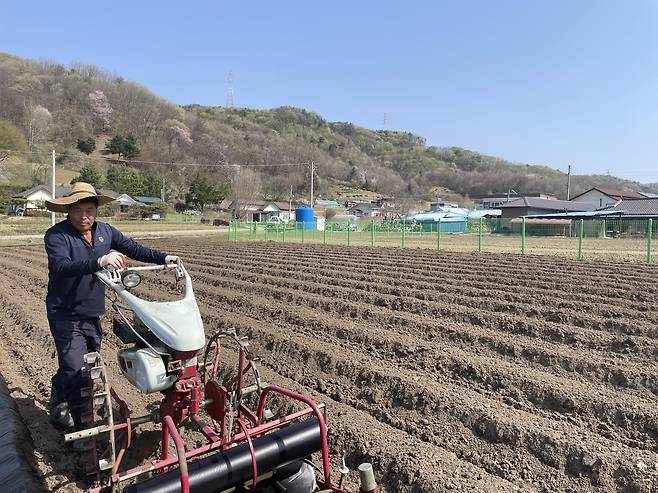 16일 충남 천안시 양곡리의 한 밭에서 유관형(61) 씨가 농기계를 이용해 두둑에 필름을 씌우며 봄 농사 준비 작업을 하고 있다. 이정훈 기자