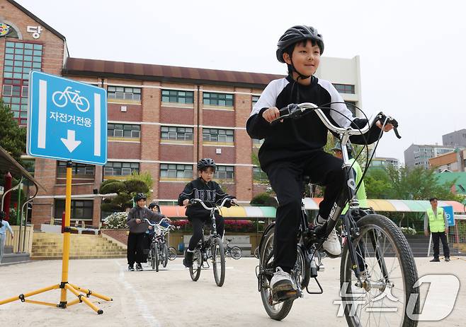 자전거의 날인 22일 경기 수원시 권선구 명당초등학교에서 열린 '2026년 찾아가는 자전거&PM(개인형 이동장치) 안전교육'에서 학생들이 교통표지판과 법규 등 안전 주행 방법을 '자전거와환경 사회적협동조합' 관계자들에게 교육받고 있다. 2026.4.22 ⓒ 뉴스1 김영운 기자