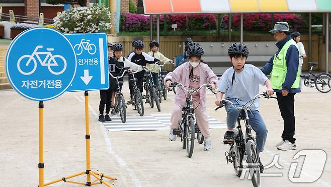 자전거의 날인 22일 경기 수원시 권선구 명당초등학교에서 열린 '2026년 찾아가는 자전거&PM(개인형 이동장치) 안전교육'에서 학생들이 교통표지판과 법규 등 안전 주행 방법을 '자전거와환경 사회적협동조합' 관계자들에게 교육받고 있다. 2026.4.22 ⓒ 뉴스1 김영운 기자