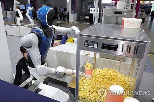 경기도 고양시 킨텍스에서 열린 2025 로보월드에서 휴머노이드 로봇이 관람객의 주문에 팝콘을 담고 있다. 사진=연합뉴스