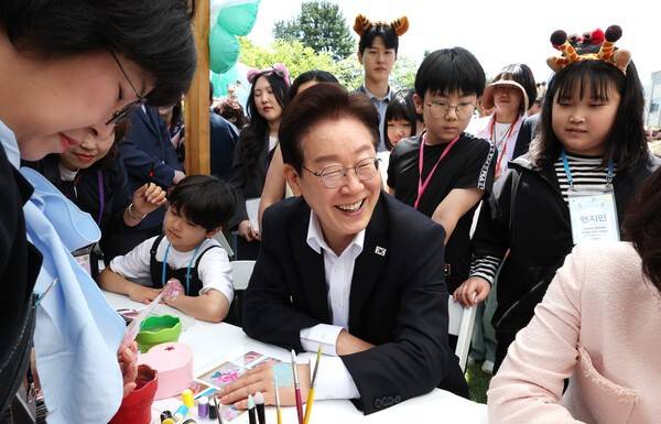 이재명 대통령이 5일 청와대 녹지원에서 열린 어린이날 초청행사에서 참석 어린이들과 함께 손등에 페인팅 체험을 하고 있다. 청와대통신사진기자단