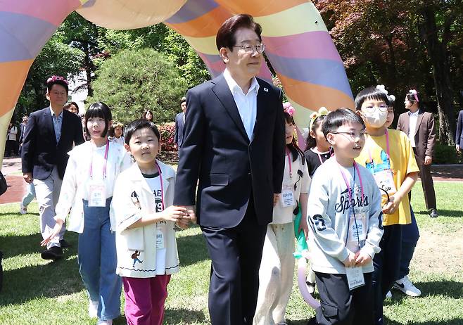이재명 대통령과 김혜경 여사가 5일 청와대에서 열린 2026 어린이날 초청행사에 참석한 어린이들과 녹지원으로 이동하고 있다. 뉴시스