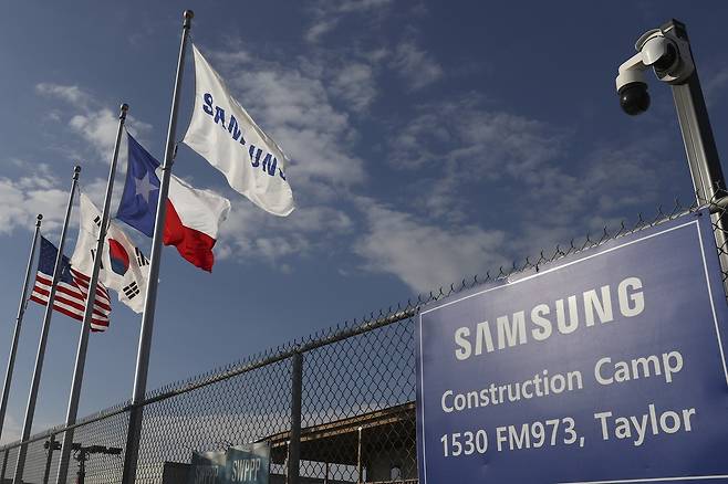 A Samsung flag flies alongside, from left, US, South Korea and Texas flags at the company's chip plant construction site in Taylor, Texas. (Reuters-Yonhap)