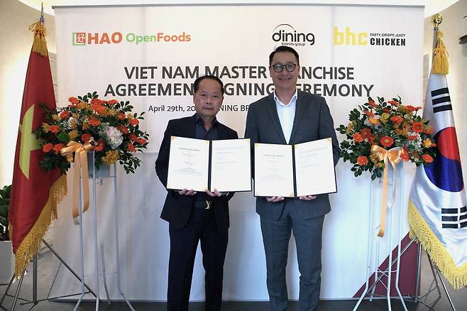 Hao Corp. CEO Tan Kim Yong (left) and Dining Brands Group CEO Song Ho-seop pose for a photo during a signing ceremony in Vietnam on April 29. (Dining Brands Group)