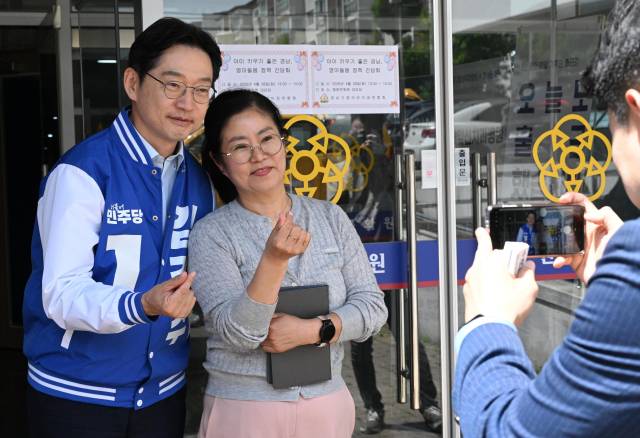 더불어민주당 김경수(왼쪽) 경남도지사 예비후보가 지난달 28일 창원문화원에서 경남가정어린이집연합회 주최로 열린 ‘영아 돌봄 간담회’에서 시민과 사진을 찍고 있다.