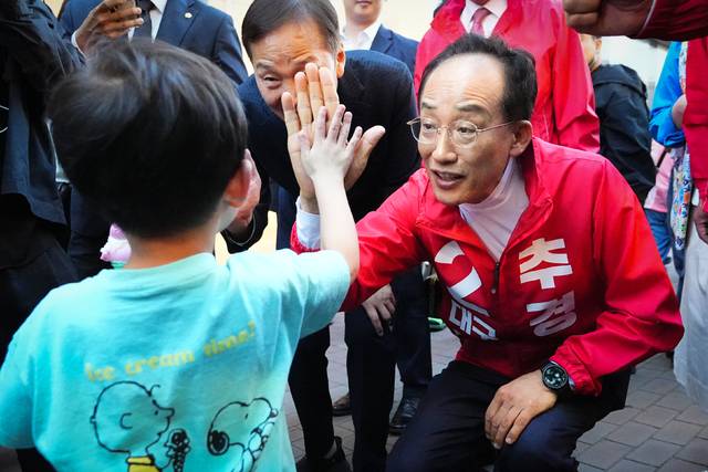 지난 9일 대구 동성로축제 현장을 방문한 추경호 국민의힘 대구시장 예비후보가 한 어린이와 하이파이브를 하고 있다. 추경호 캠프 제공