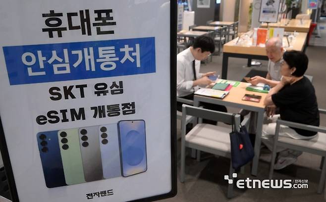 서울 용산구 전자랜드 휴대폰 매장에서 고객이 SK텔레콤 이심 개통상담을 받고 있다. 김민수기자 mskim@etnews.com