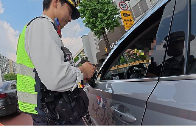 지난 12일 오후 2시 40분께 서울 강남구 대치역 사거리에서 경찰이 직진 차선에서 좌회전 차선으로 끼어든 택시를 단속하고 있다. 이영기 기자.
