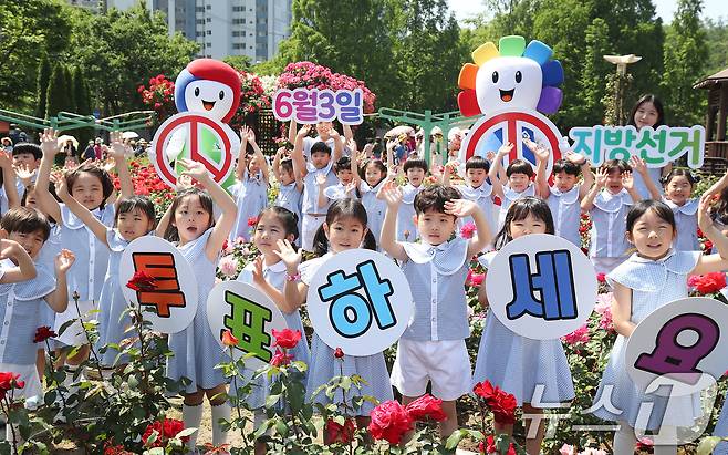 제9회 전국동시지방선거가 21일 앞으로 다가온 13일 대구 달서구 이곡장미공원에서 대구시선관위와 솔리유치원 어린이들이 곱게 핀 장미를 배경으로 '6·3 장미지선 투표참여 캠페인'을 진행하고 있다. 2026.5.13 ⓒ 뉴스1 공정식 기자