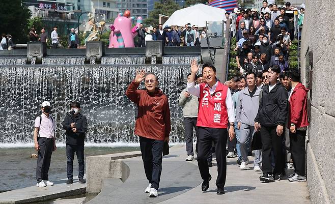 오세훈 국민의힘 서울시장 후보가 15일 서울 청계천에서 만난 이명박 전 대통령과 시민들에게 인사하고 있다. 뉴스1