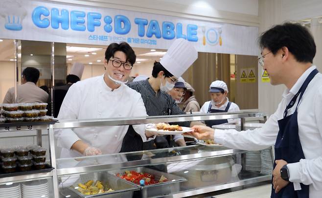 지난 12일 동원홈푸드가 운영하는 LIG디펜스&에어로스페이스 용인하우스 구내식당에서 오세득 셰프가 임직원에게 특식을 배식하고 있다./사진제공=동원홈푸드